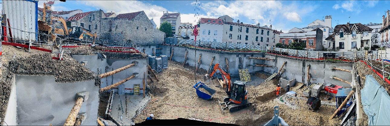 Fond de fouille en milieu urbain dense, mini-pelles et bennes au pied de murs mitoyens